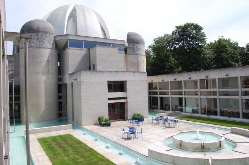 Wide view of white concrete dome over the terrace and waterways of Fountain Court at Murray Edwards college, Cambridge