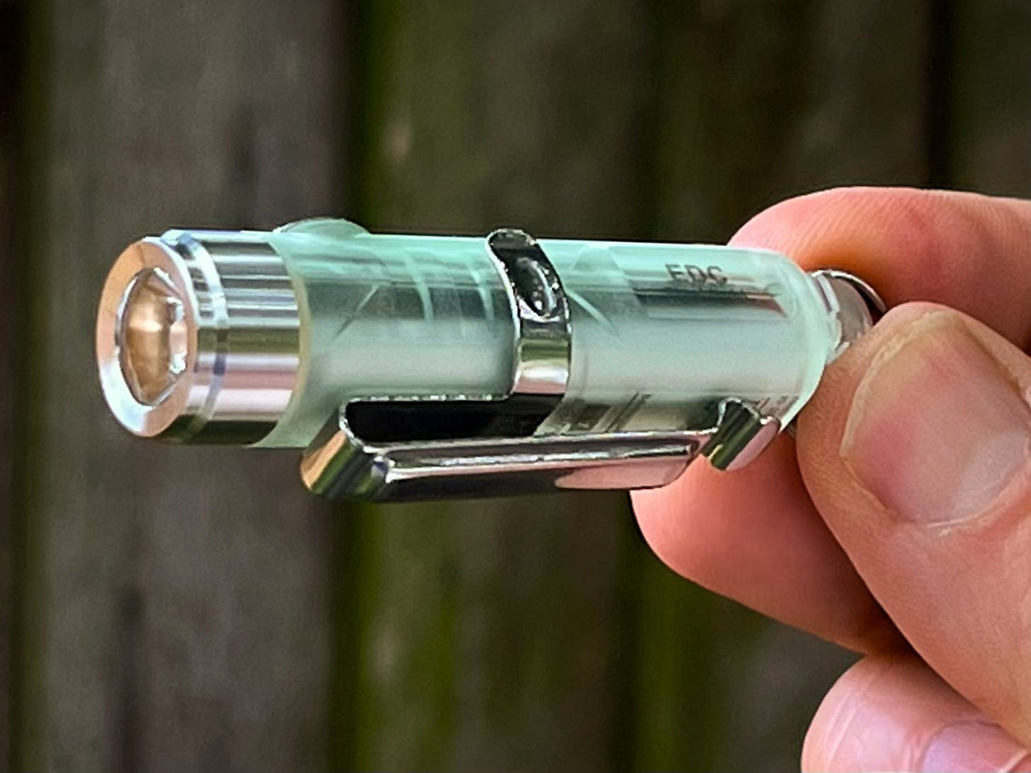 A small flash being held in the hand the letters EDC can be seen on the side, which means every day carry