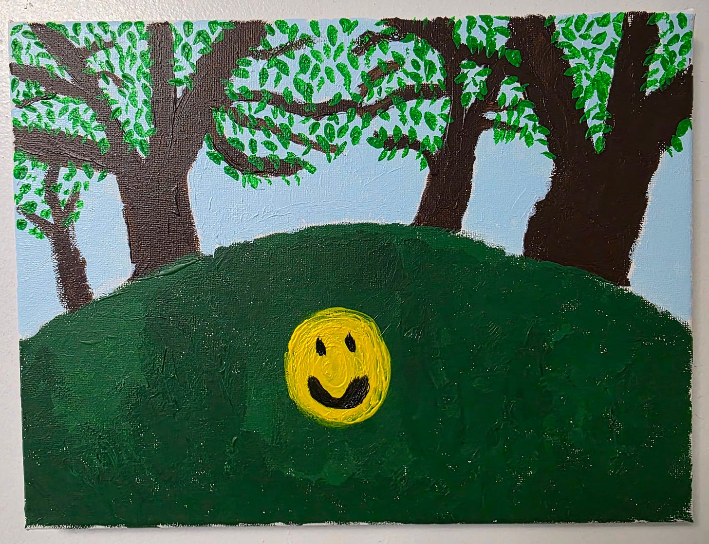 Painting of three leafy trees on a grassy hill with a bright yellow smiley face in the center foreground. Painting of three leafy trees on a grassy hill with a bright yellow smiley face in the center foreground.