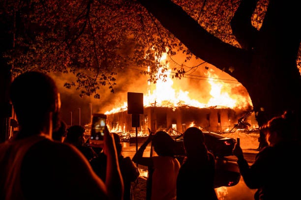 People look on as a construction site burns in a large fire near the Third Police Precinct on May 27, 2020 in Minneapolis, Minnesota. A number of...