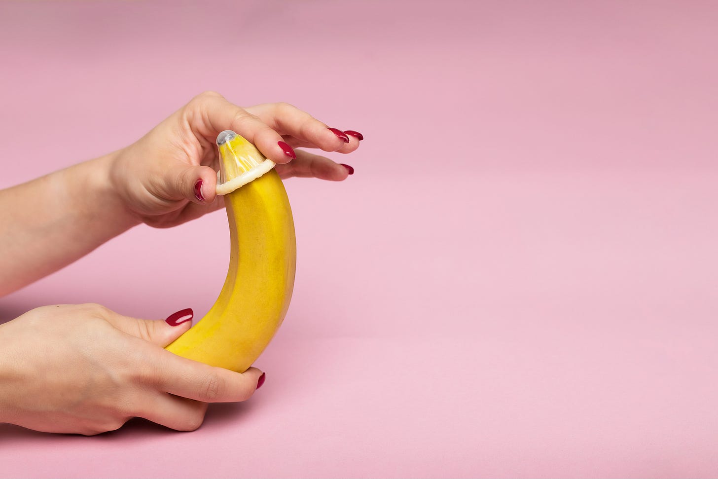 a woman putting a condom on a banana