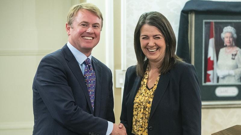 Tyler Shandro (left) shaking hands with Danielle Smith (right)