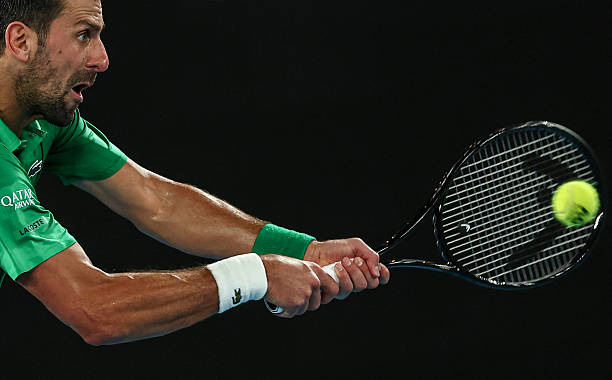 Serbia's Novak Djokovic hits a return against Italy's Jannik Sinner during their men's singles semi-final match on day thirteen of the Australian...