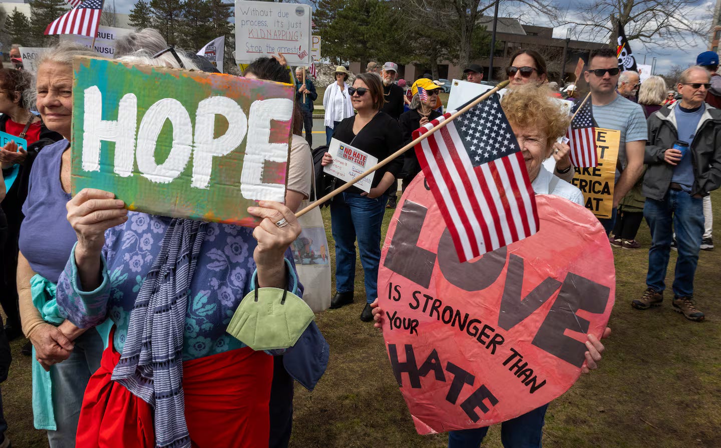 Protestors outside an ICE facility in Burlington, MA hold signs. Protestors outside an ICE facility in Burlington, MA hold signs.