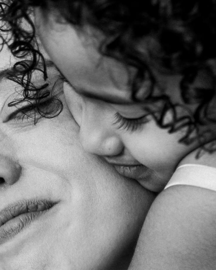 This may contain: a woman holding a child in her arms