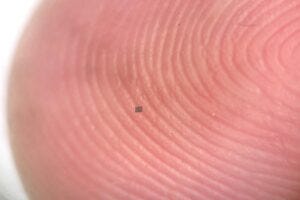 A microrobot, fully integrated with sensors and a computer, small enough to balance on the ridge of a fingerprint.