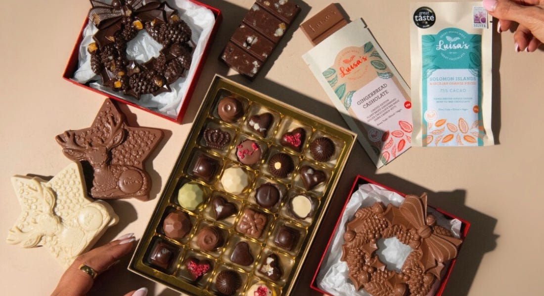 A collection of chocolate bars, boxes, stars, and wreaths on top of a brown table A collection of chocolate bars, boxes, stars, and wreaths on top of a brown table