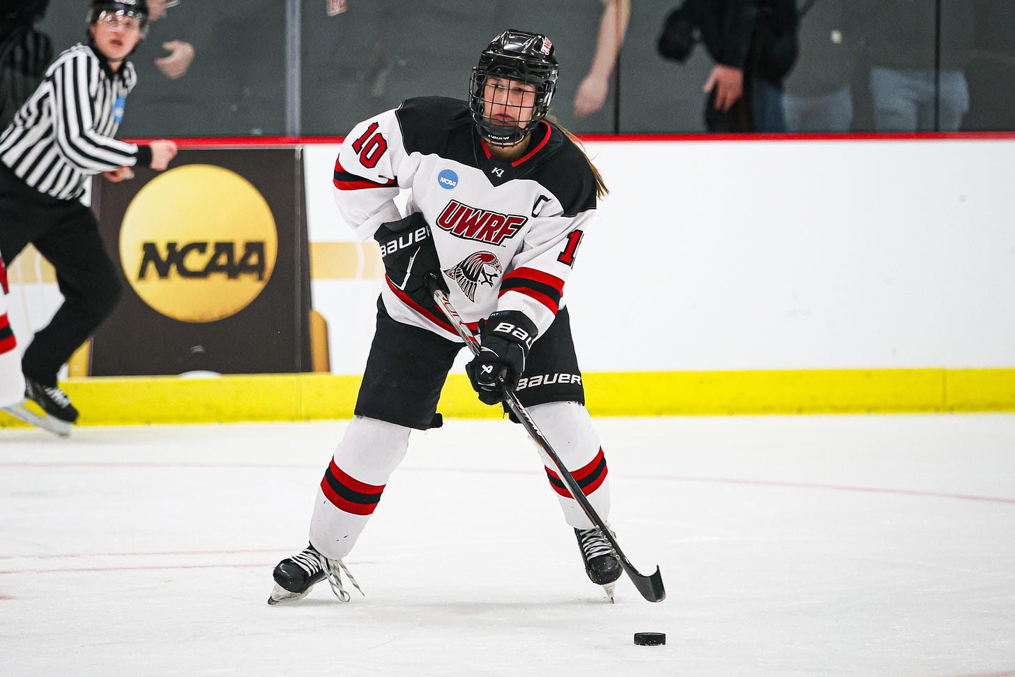 Megan Goodreau, a women's college hockey player, handles the puck on her stick while looking up ice Megan Goodreau, a women's college hockey player, handles the puck on her stick while looking up ice