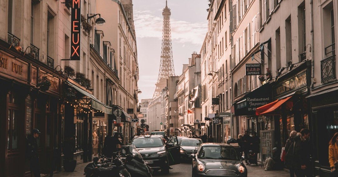 vehicles travelling on road surrounded by buildings during daytime