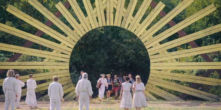 This may contain: a group of people standing in front of a large wooden structure that looks like a sunburst This may contain: a group of people standing in front of a large wooden structure that looks like a sunburst