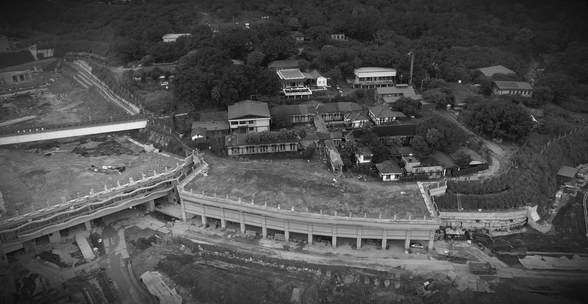 Several small buildings at Taipei's Losheng Sanitorium lie above a massive construction site that cuts them off from the surrounding neighborhood