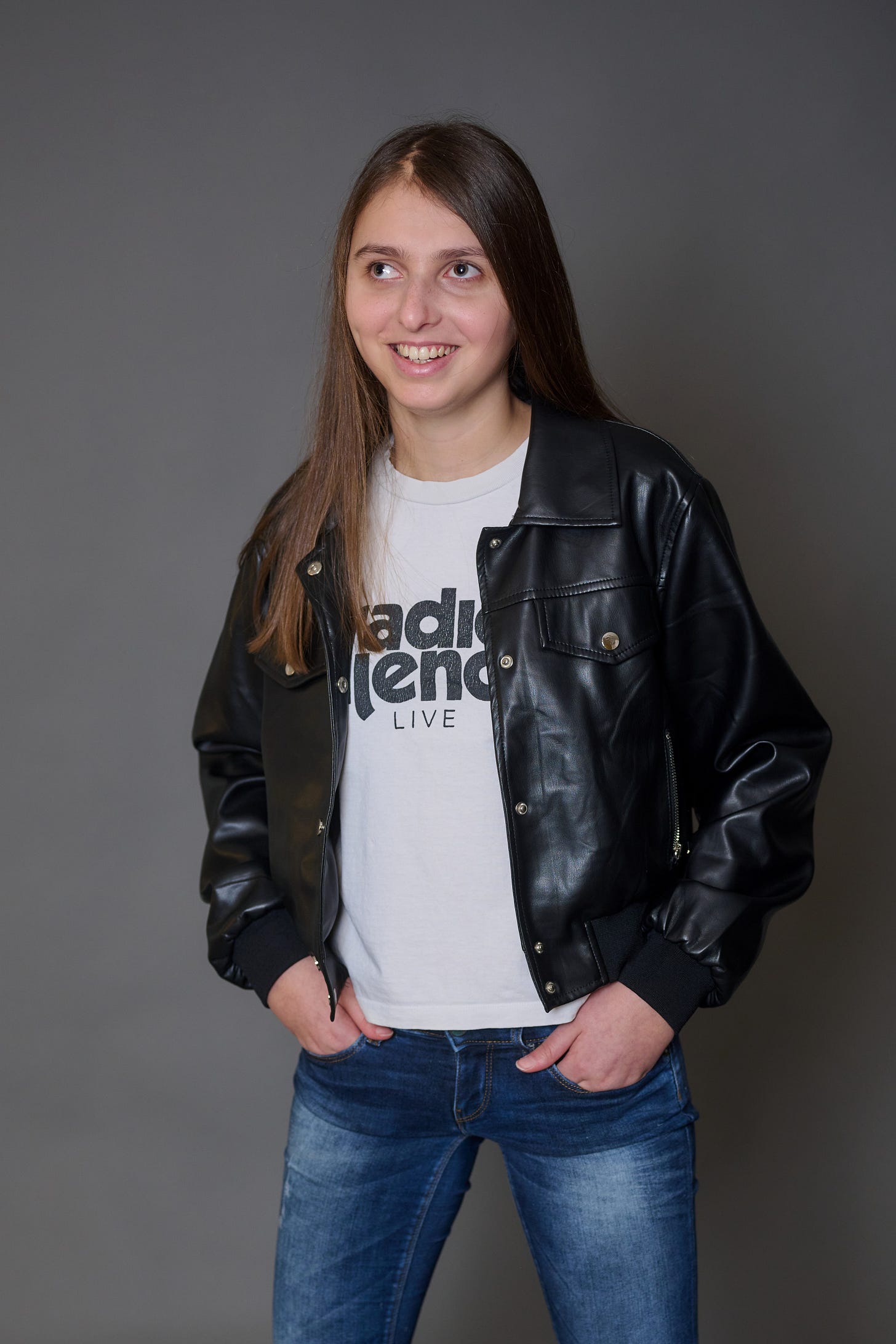 Portrait of Sofia Reyna taken by an Austrian photographer. Sofia is has long brown hair, light skin and green eyes. She is wearing a black leather jacket with a white t-shirt and jeans.