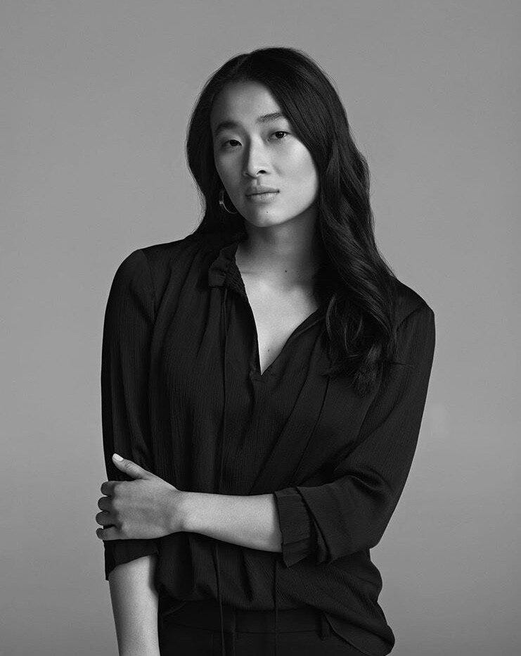 Black and white headshot of Nadya wearing a black top 