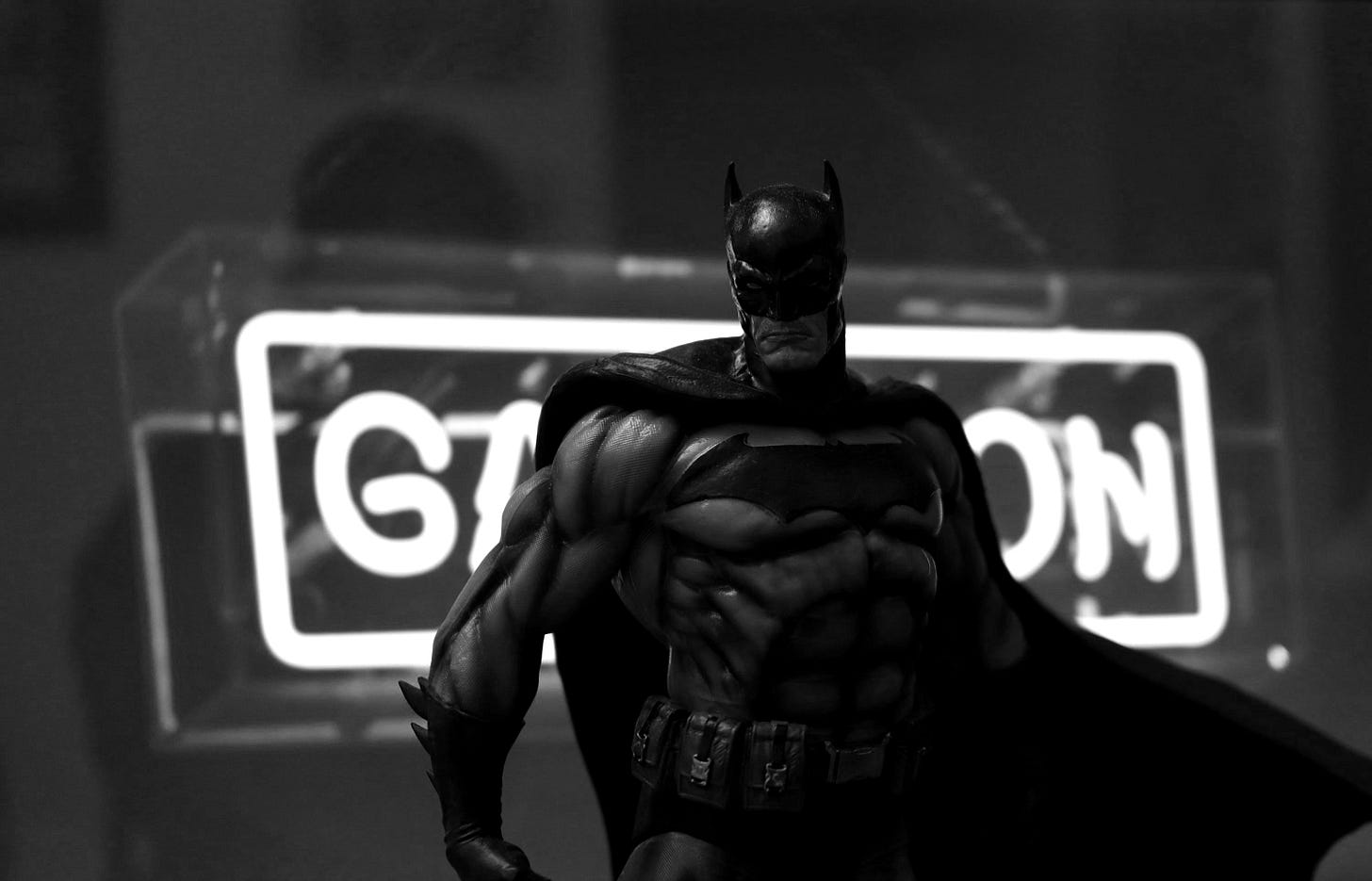 a batman standing in front of a neon sign