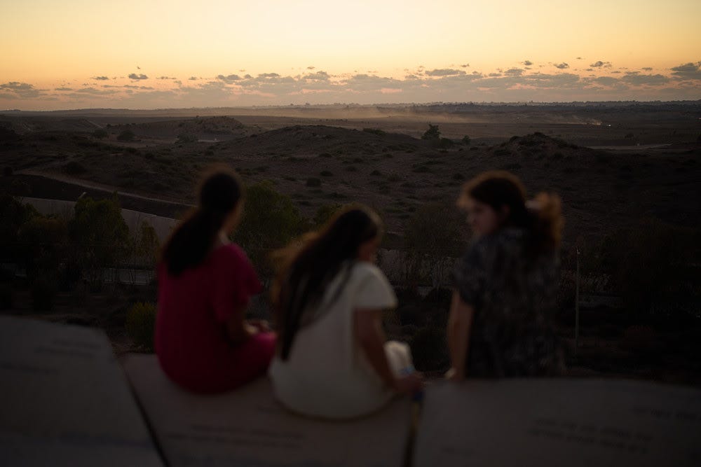 People observe buildings that were destroyed during the Israeli ground and air operations in the northern of Gaza Strip as they visit a sightseeing area in Sderot, southern Israel, Tuesday, Oct. 14, 2025. (AP Photo/Leo Correa)