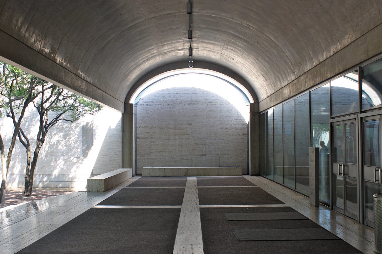 a vaulted porch in the Kimbell Art Museum with a wash of light on a travertine wall