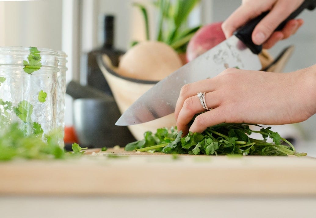 person cutting vegetables with knife