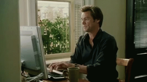a man is sitting in front of a computer with a cup of coffee . a man is sitting in front of a computer with a cup of coffee .