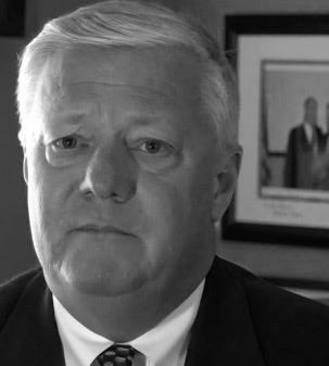 Wearing a suit, Kenneth Williams looks into the camera with a serious expression Wearing a suit, Kenneth Williams looks into the camera with a serious expression