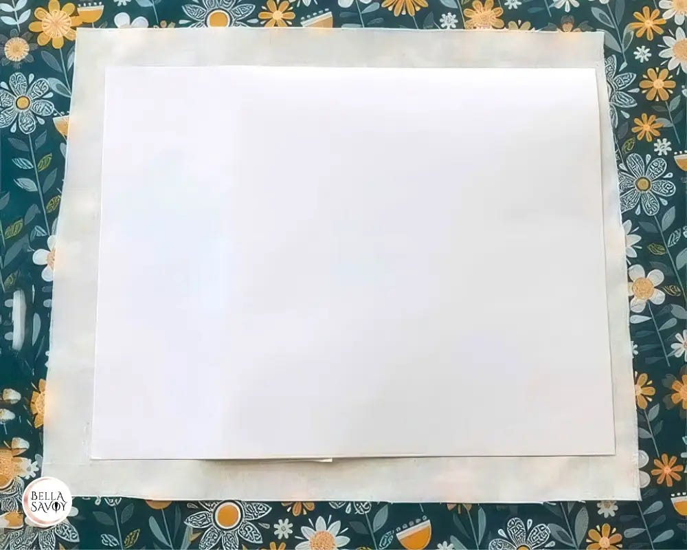 8.5x11 inch sticker sitting on fabric with a portion of the backing folded under