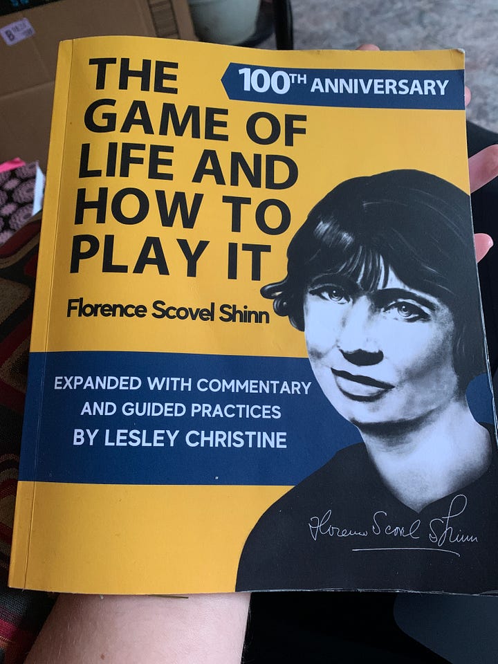 Girl holding book The Game of Life and How to Play It