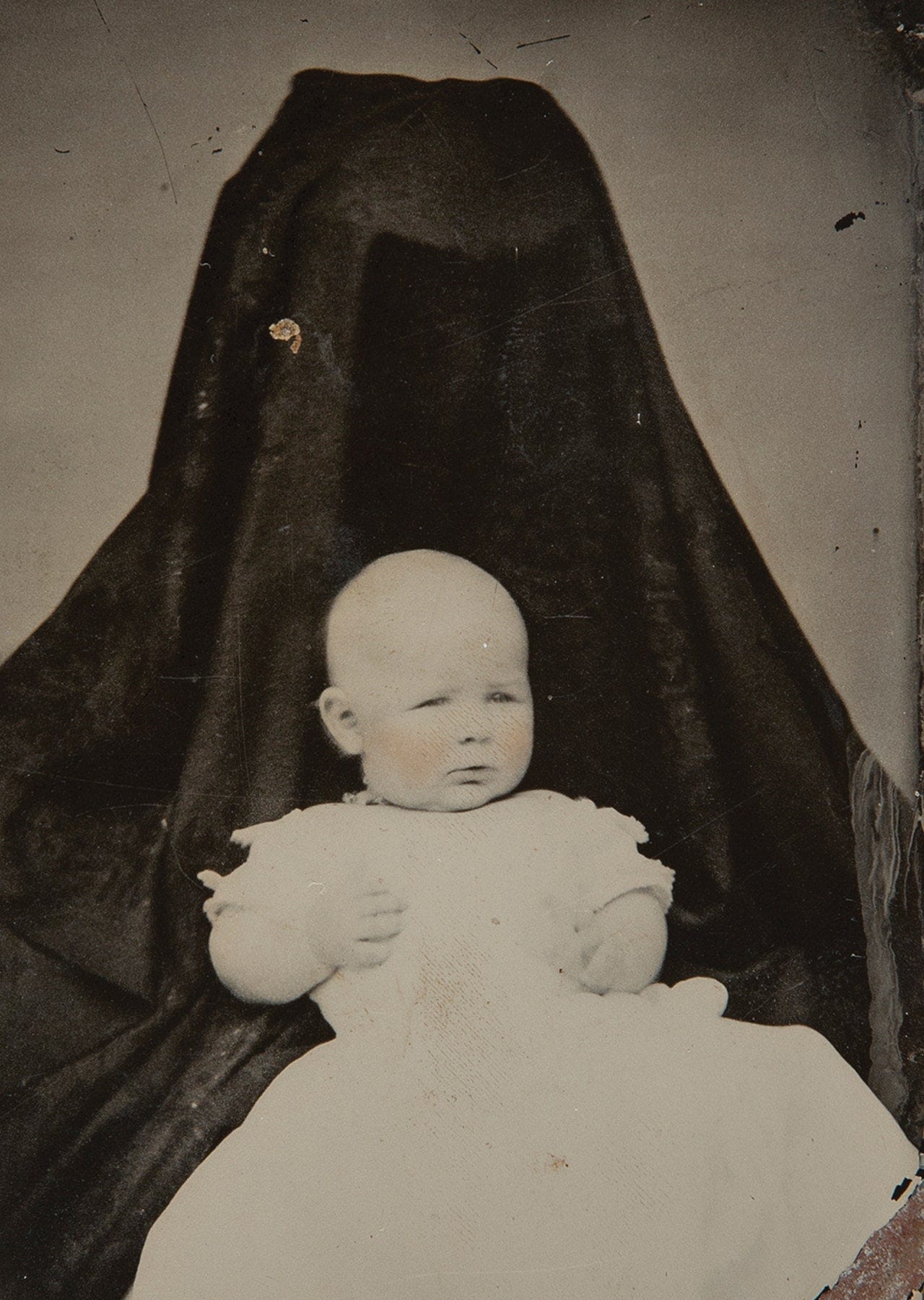 A child sitting in an obscured adult's lap.