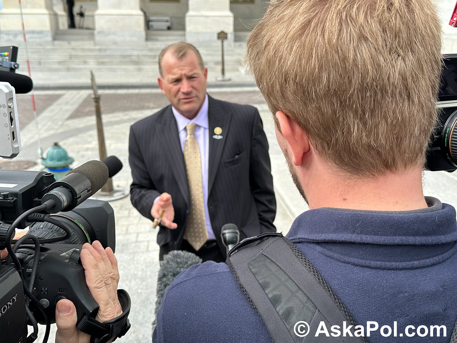 Politician smoking a cigar answers reporters questions. Photo Matt Laslo © Ask a Pol Crypto