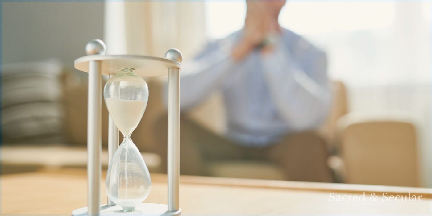 An hourglass sits in sharp focus on a table while a blurred figure sits thoughtfully in the background, reflecting on the passage of time. An hourglass sits in sharp focus on a table while a blurred figure sits thoughtfully in the background, reflecting on the passage of time.
