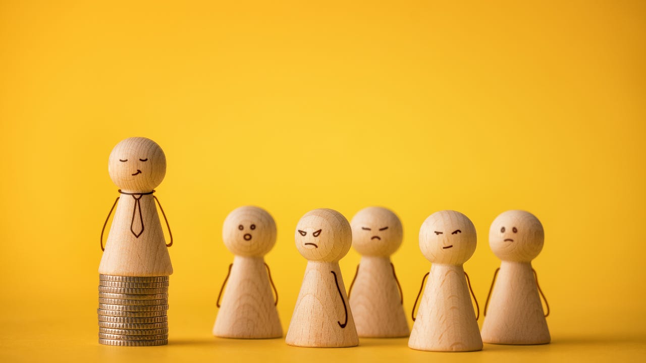 Wooden figures standing by a wooden figure on a stack of coins. Wooden figures standing by a wooden figure on a stack of coins.