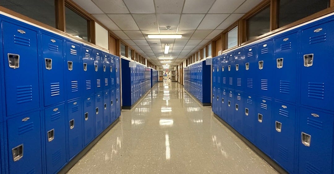 a long hallway lined with blue lockers in a building a long hallway lined with blue lockers in a building