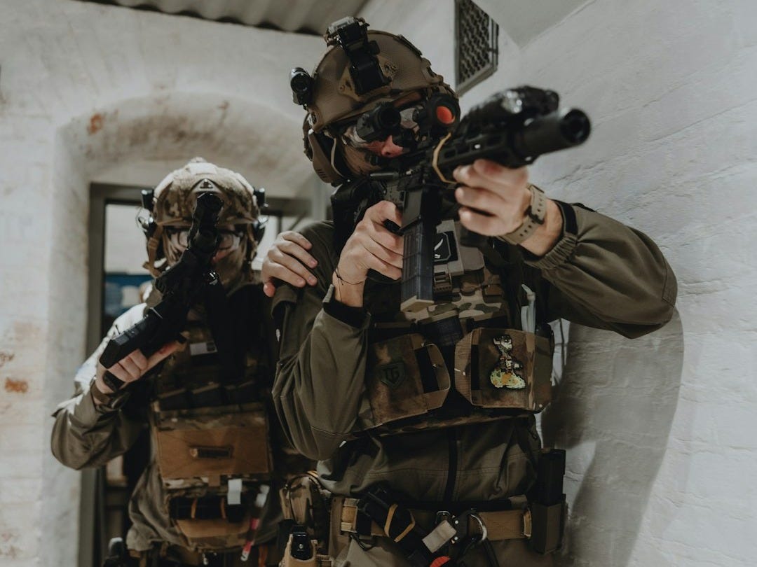 a man holding a gun while standing next to another man