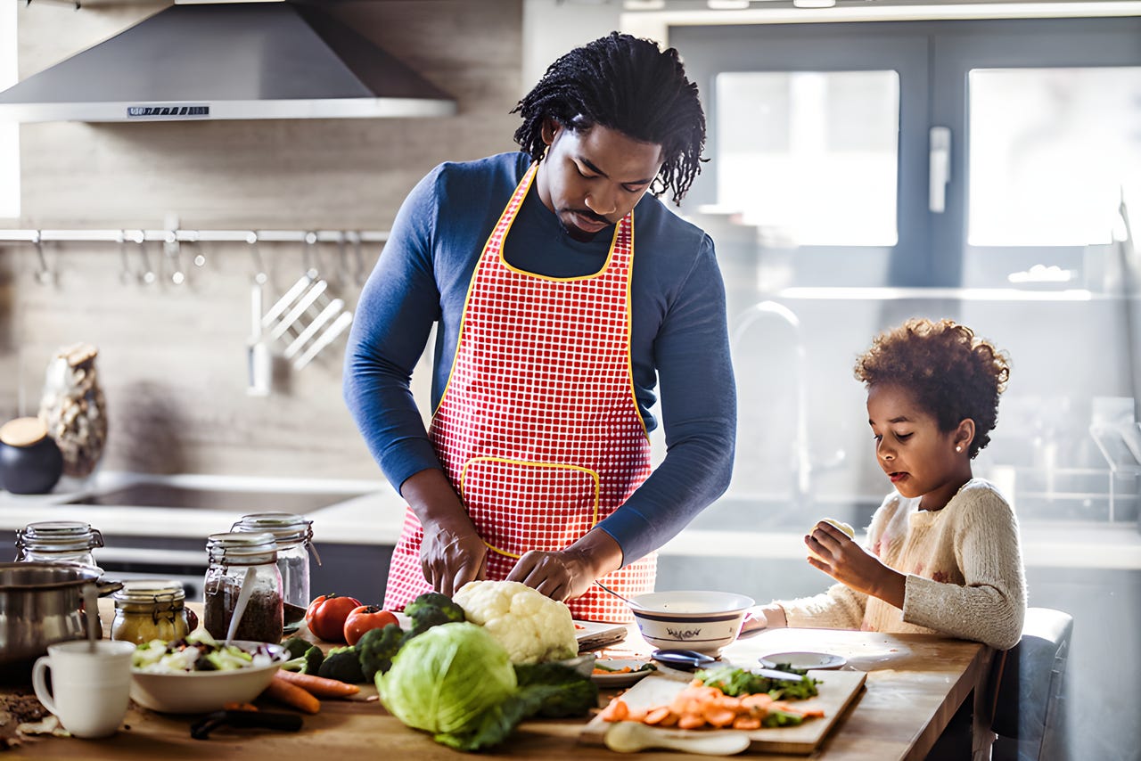 Parent and child preparing vegetables for cooking in a kitchen.