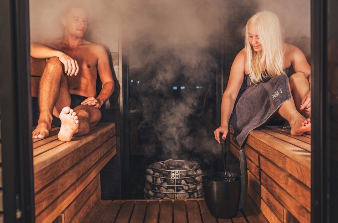 A couple of people that are sitting in a sauna A couple of people that are sitting in a sauna