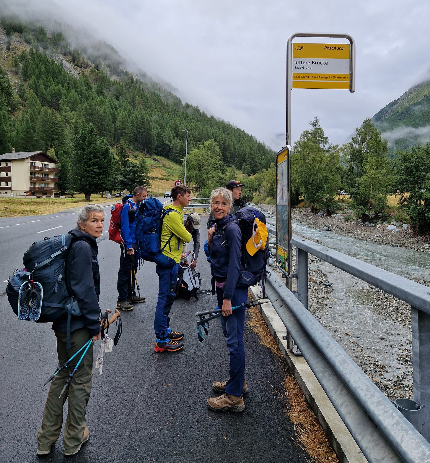 Group of hikers on road by a bus stop Group of hikers on road by a bus stop