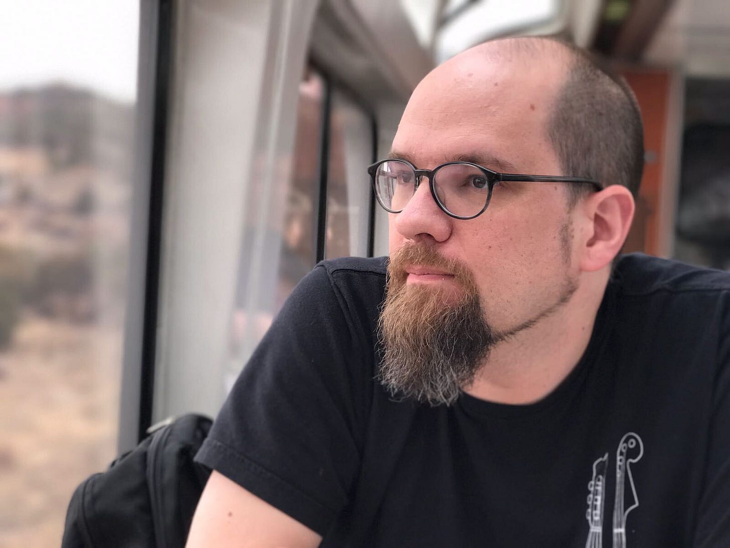 Headshot of Phil Gomes on a train