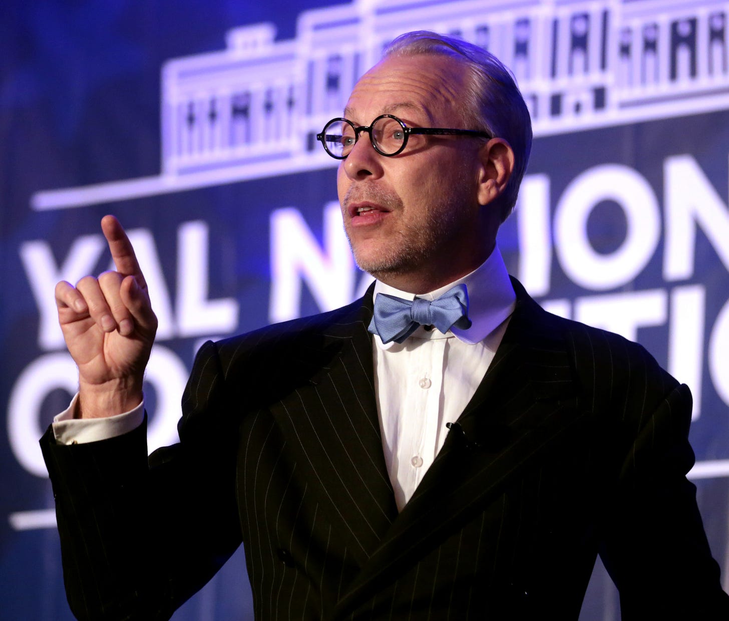 Jeffrey Tucker raises a finger while speaking on stage at a YAL National Convention backdrop. Jeffrey Tucker raises a finger while speaking on stage at a YAL National Convention backdrop.