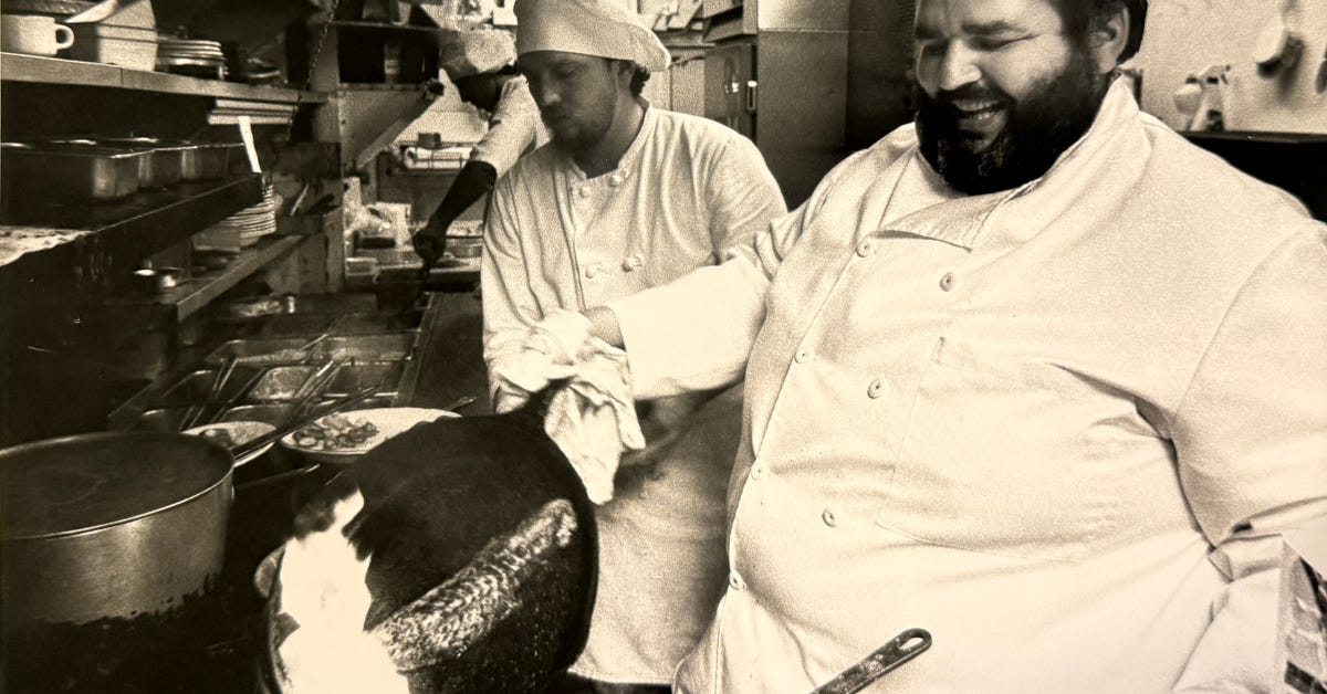 A picture of Chef Paul Prudhomme smiling in the kitchen holding a cast iron skillet A picture of Chef Paul Prudhomme smiling in the kitchen holding a cast iron skillet