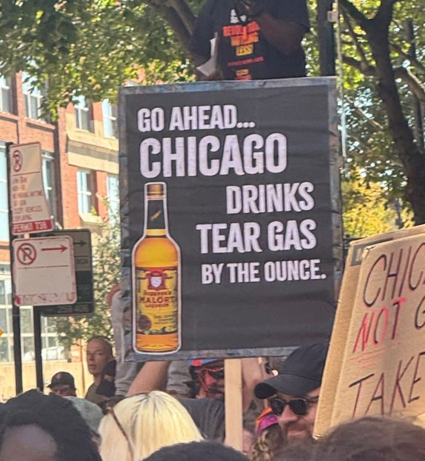 A protest sign with a bottle of Mälort depicted on it with the following words: GO AHEAD, CHICAGO DRINKS TEARGAS BY THE OUNCE.