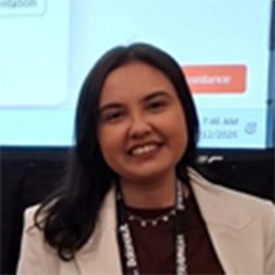 Mulher de cabelos longos e escuros, sorrindo para a câmera. Ela veste blazer branco sobre blusa marrom. Mulher de cabelos longos e escuros, sorrindo para a câmera. Ela veste blazer branco sobre blusa marrom.