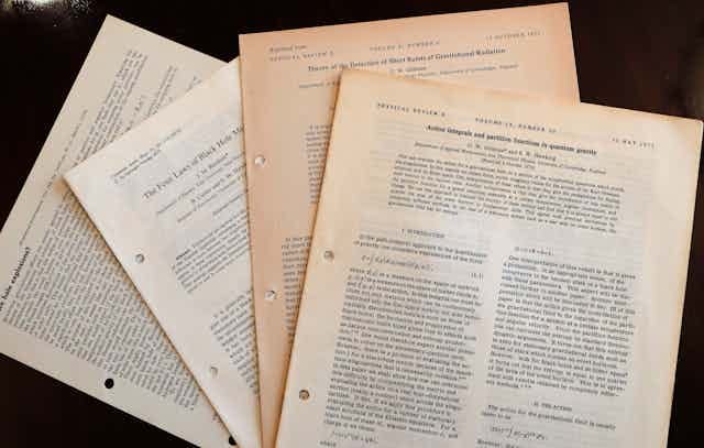 A stack of yellowing research papers. A stack of yellowing research papers.