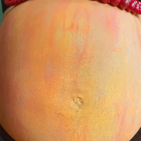 Rainbow Squared Year 5 Piece Twenty-One: 8. Orange Red. Photo animation of strings of beads continuously rolling over an orange-painted pregnant belly.