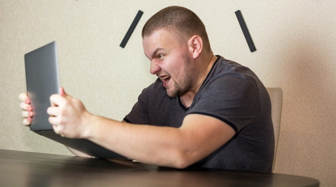 a man sitting in front of a laptop computer a man sitting in front of a laptop computer