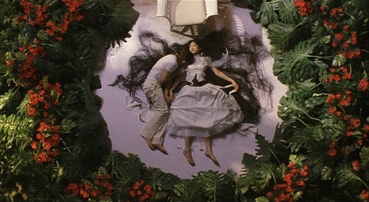 This may contain: two people are laying on the ground surrounded by flowers