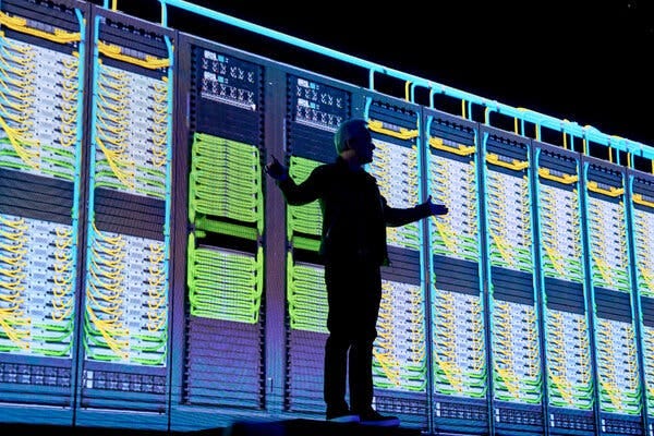 Jensen Huang, in dark profile against a brightly lit background of purple, yellow and green computer boards.