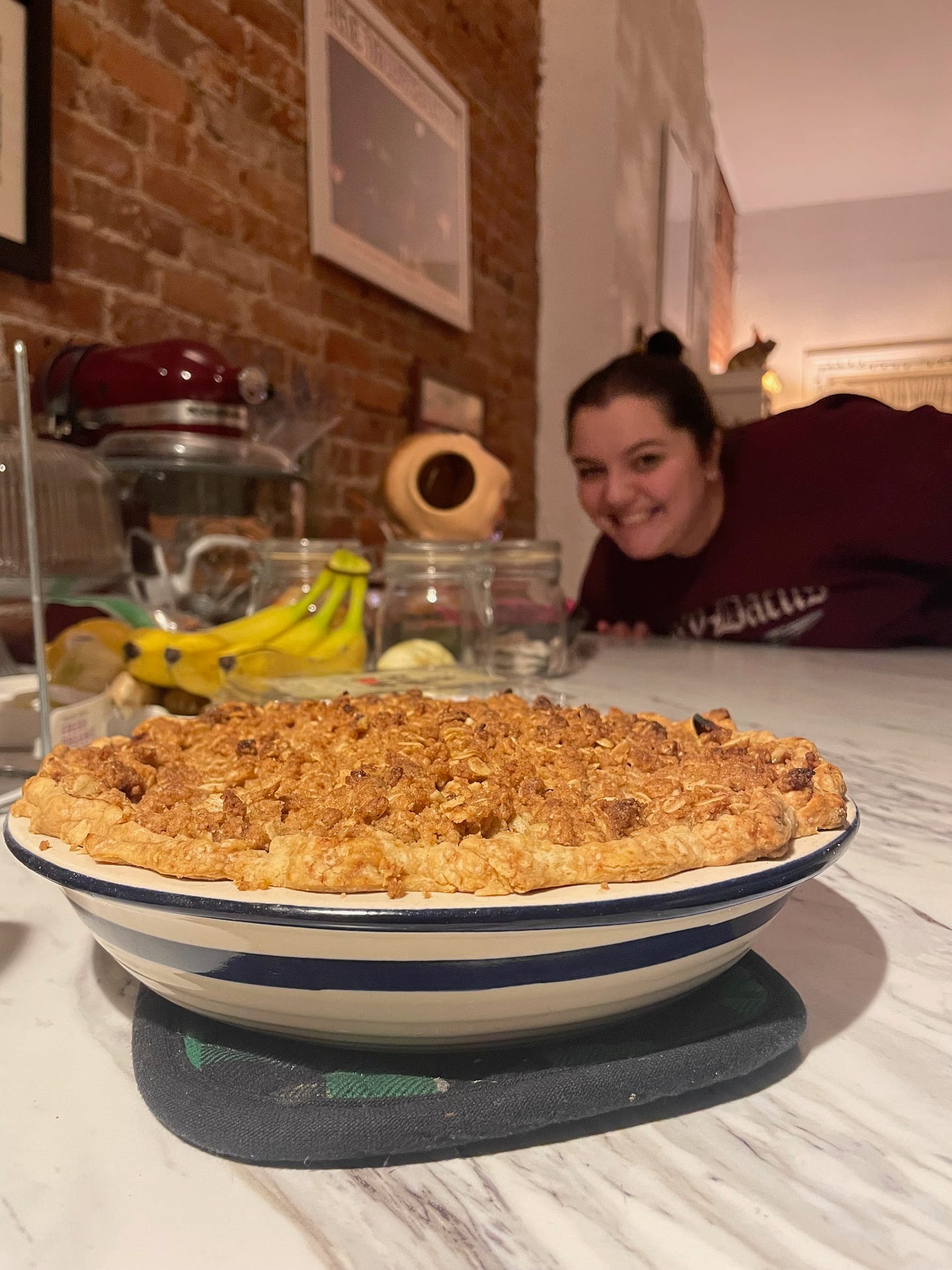 a pie on the counter with Sarah in the background