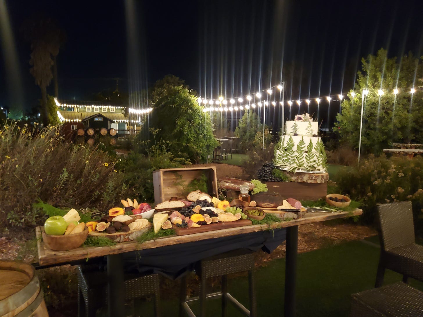 A wedding table setting with cheeses, fruits, and a wedding cake for the movie The Not by Courtney Hoskins
