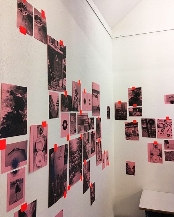 This may contain: a white wall with red and black pictures on it