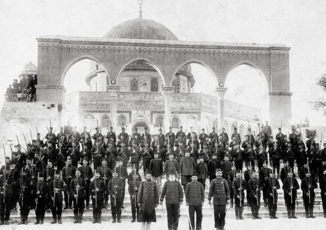 Ottoman soldiers stand guard outside Qubbat as-Sakhra (Dome of the Rock) within the Al Aqsa Compound, circa 1889, a rare historical perspective.