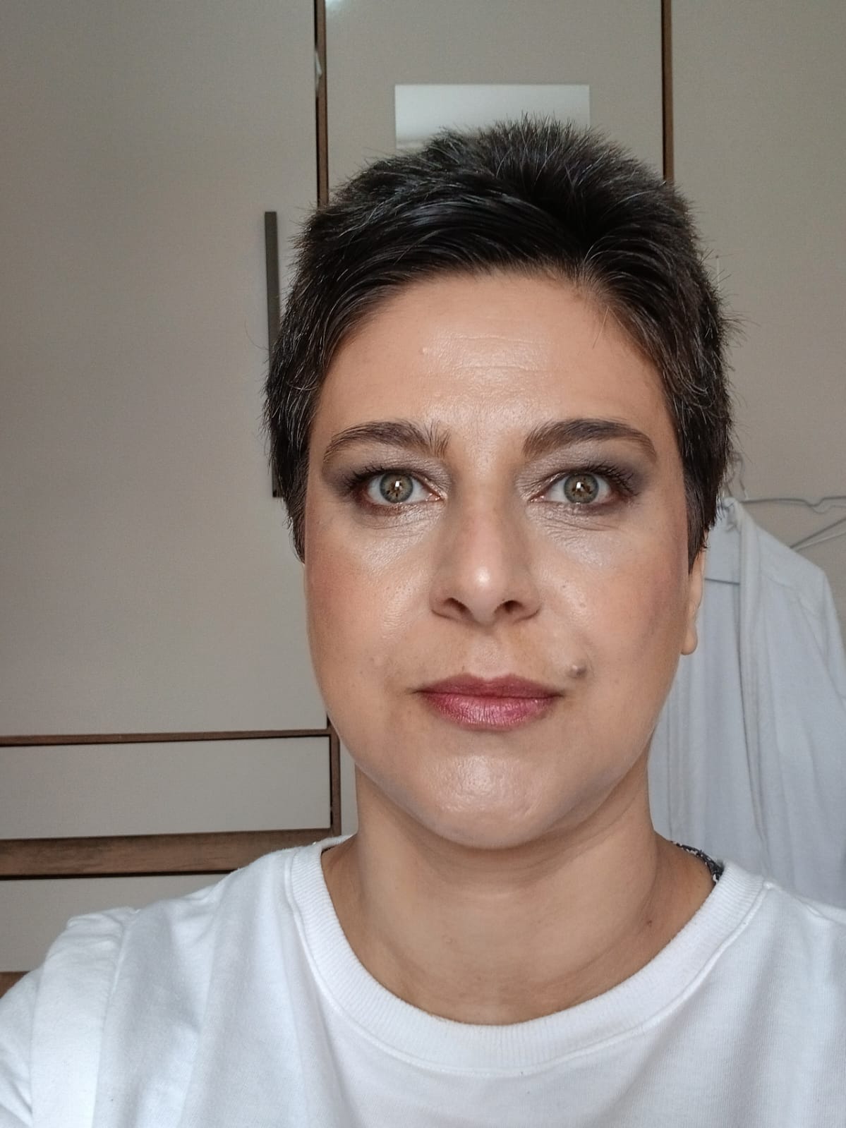 Retrato em close de Oryanna Borges olhando fixamente para a câmera. Ela tem cabelos pretos bem curtos e olhos verdes expressivos, ilustrando a presença e a intensidade do ensaio literário