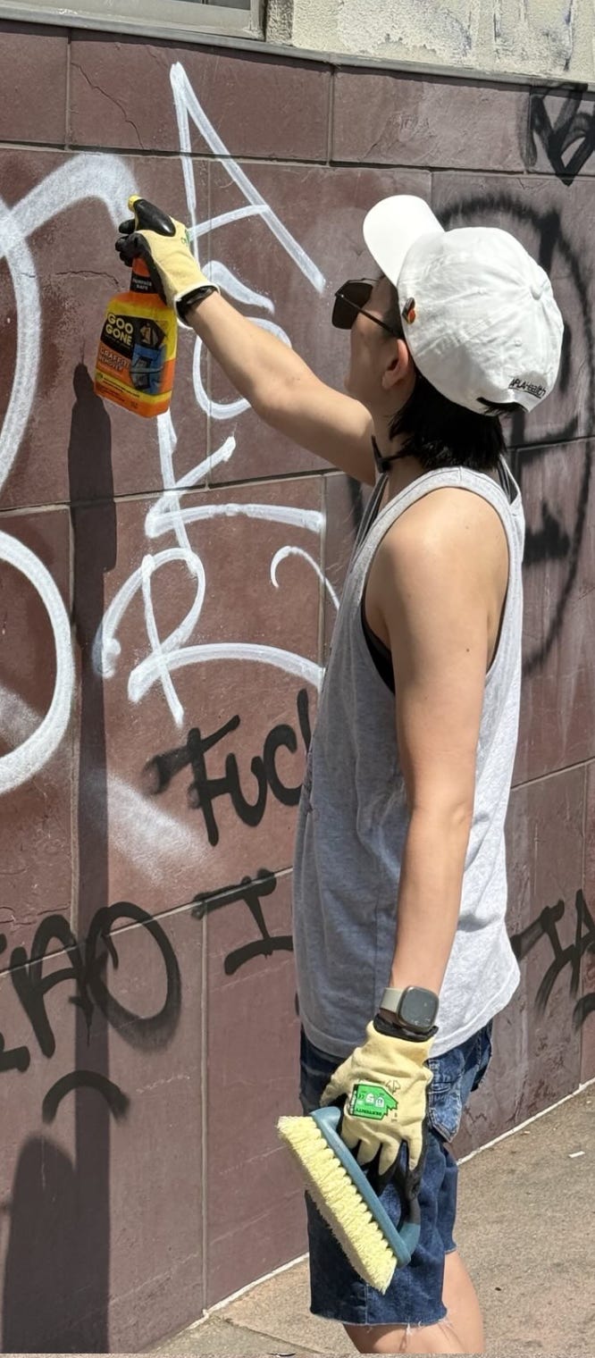 Author spraying the graffiti with a cleaner.